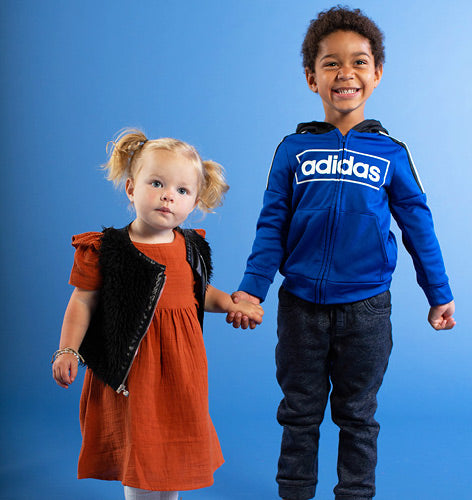 Toddler girl smiling wearing a maroon dress.